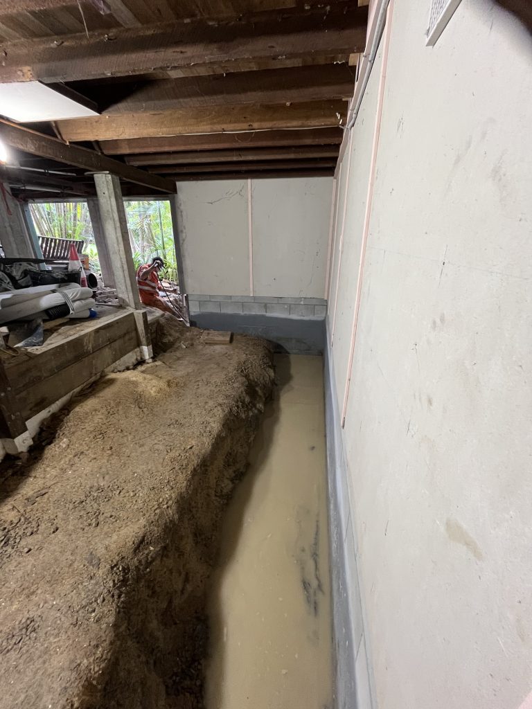 Vacuum excavated trench around a house where the builder's drainage install had failed almost immediately after handover.