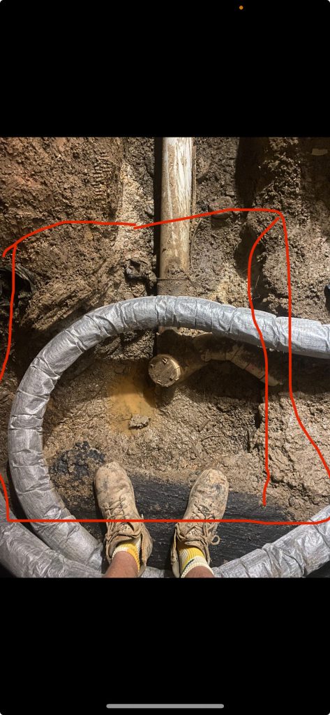 Vacuum excavated area around a Brisbane house showing builders debris and an underwater spring forcing water back toward the foundation.