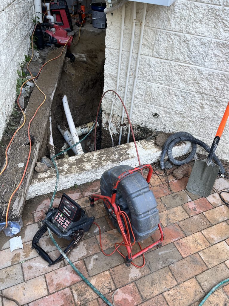 Vacuum excavation setup on a steep block where a stormwater line had come apart underground.